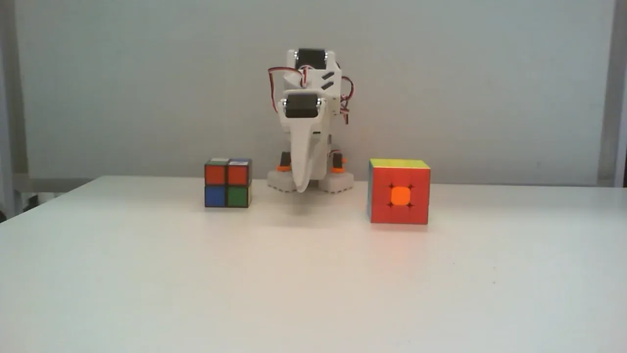 Front camera view of the Rubik's Stack workspace with a larger and smaller Rubik's cube on the tabletop.